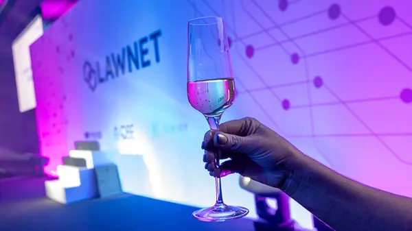 raising a glass of Champagne by the LawNet logo